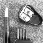ein Fallminenstift mit Ersatzminen und Spitzer auf einer Filzunterlage